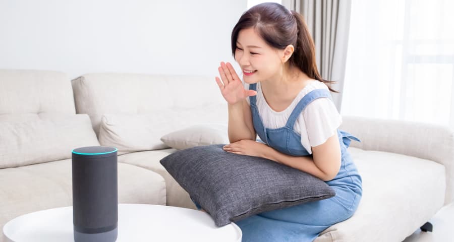 Young woman speaking a voice command to a smart assistant